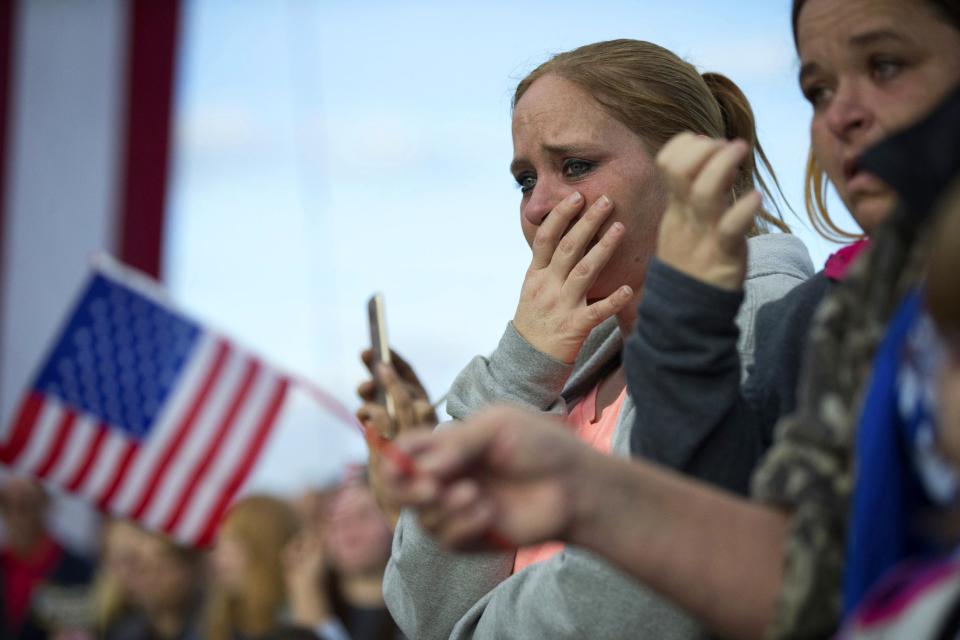 A woman reacts as a caisson carrying the casket of Americus Police Officer Nicholas Smarr proceeds to the burial site at Oak Grove Cemetery, Sunday, Dec. 11, 2016, in Americus, Ga. Smarr and his lifelong friend, Georgia Southwestern State University campus police officer Jody Smith, were killed responding to a domestic violence call on Wednesday. (AP Photo/Branden Camp)