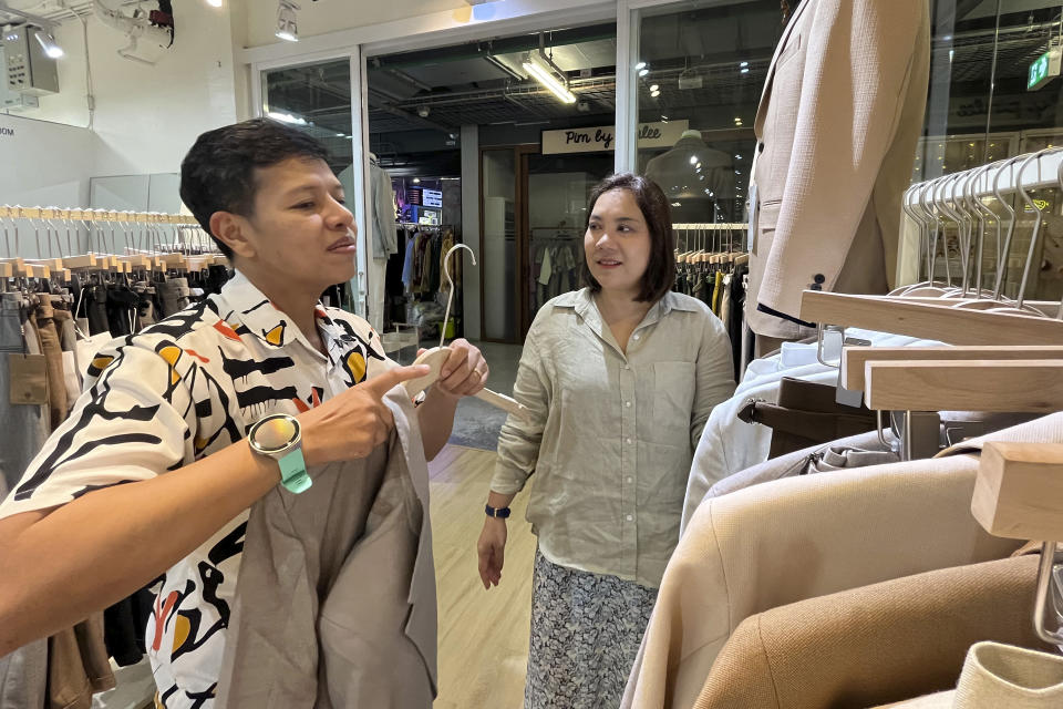 An LGBTQ couple, Naphat Krutthai, left, a transgender man, and Rasithaya Jindasri, help each other to select clothes in Bangkok, Thailand, Tuesday, Dec. 5, 2023. Thailand's Parliament is set to debate Thursday, Dec. 21, a final cabinet-endorsed draft bill to pass landmark legislation allowing members of the LGBTQ+ community to get married. (AP Photo/Sakchai Lalit)