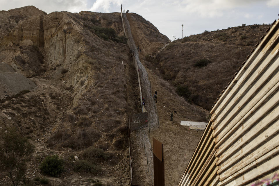 The border wall between Mexico and US on December 1, 2018. Honduran migrants are trapped between the wall and the barber wire in US territory. (Photo: Fabio Bucciarelli for Yahoo News)