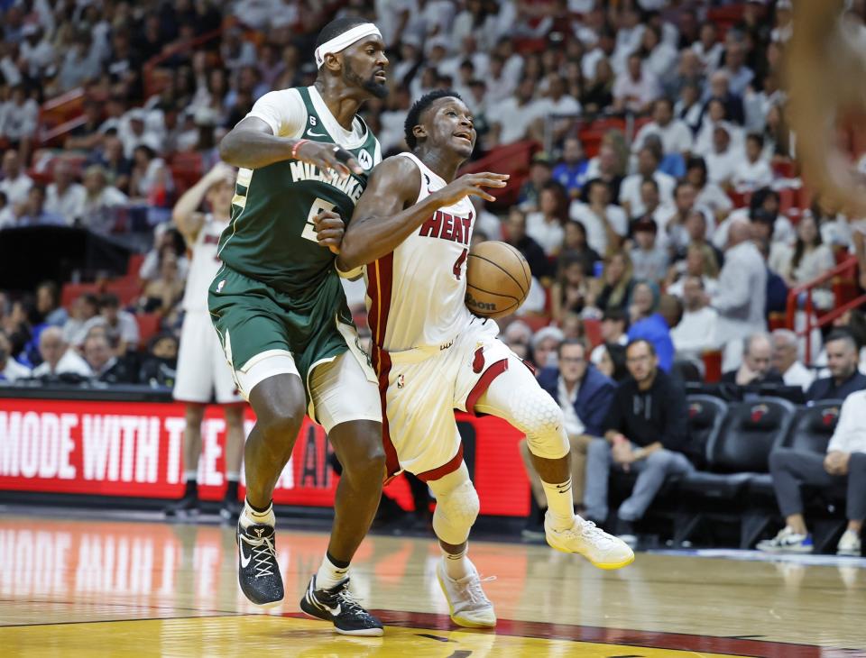 Miami Heat guard Victor Oladipo (4) drives to the basket as Milwaukee Bucks forward Bobby Portis (9) defends moments before Oladipo comes up injured during the second half of Game 3 in a first-round NBA basketball playoff series against the Milwaukee Bucks, Saturday, April 22, 2023, in Miami. (Al Diaz/Miami Herald via AP)