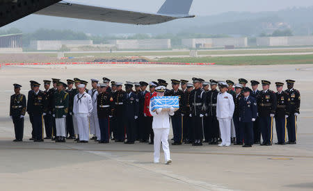 A U.N. honor guard carries a box containing remains believed to be from American servicemen killed during the 1950-53 Korean War after it arrived from North Korea, at Osan Air Base in Pyeongtaek, South Korea, Friday, July 27, 2018. Ahn Young-joon/Pool via Reuters