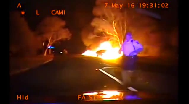 A policeman runs out of the way as the car gathers speed down the hill. Photo: ACT Police