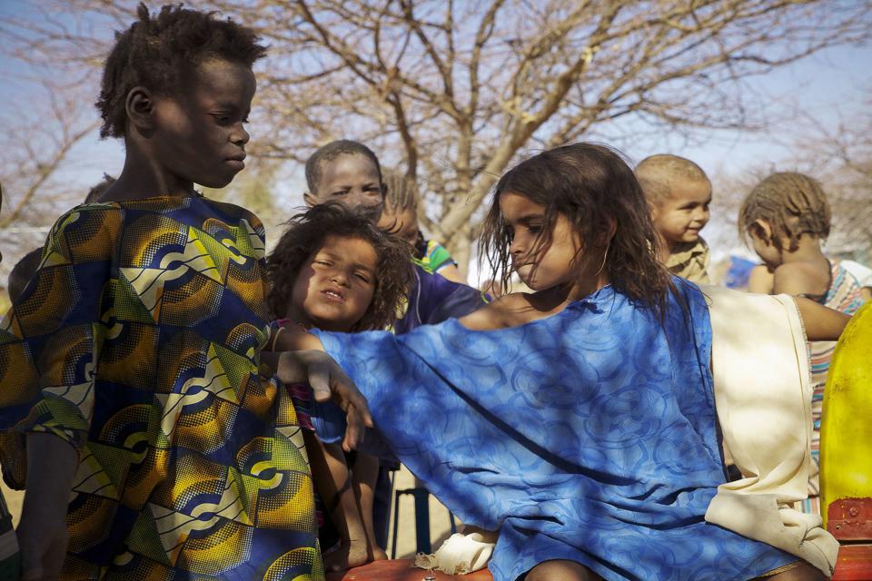 A Tuareg child pushes away a Bella girl (L) at a camp for Malian refugees in Goudebou, Burkina Faso, April 5, 2014. Half a million people fled the conflict in Mali, some crossing the border to neighbouring Burkina Faso. Fleeing Tuaregs took with them their livestock and servants from the Bella ethnic group, a marginalised people who for centuries have been kept in slave-like conditions throughout Mali, Niger and Mauritania. To match story MALI-SLAVES/ Picture taken April 5, 2014. REUTERS/Misha Hussain (BURKINA FASO - Tags: SOCIETY IMMIGRATION TPX IMAGES OF THE DAY)