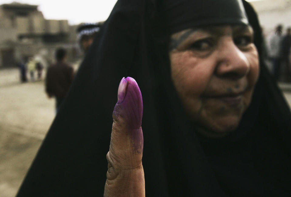 <p>A woman displays her ink-stained finger outside a polling station after voting on Election Day in the Sadr City neighborhood of Baghdad January 30, 2005 in Baghdad, Iraq. Iraq ‘s first multiparty elections in half a century began at 7am on Sunday. (Photo by Chris Hondros/Getty Images) </p>