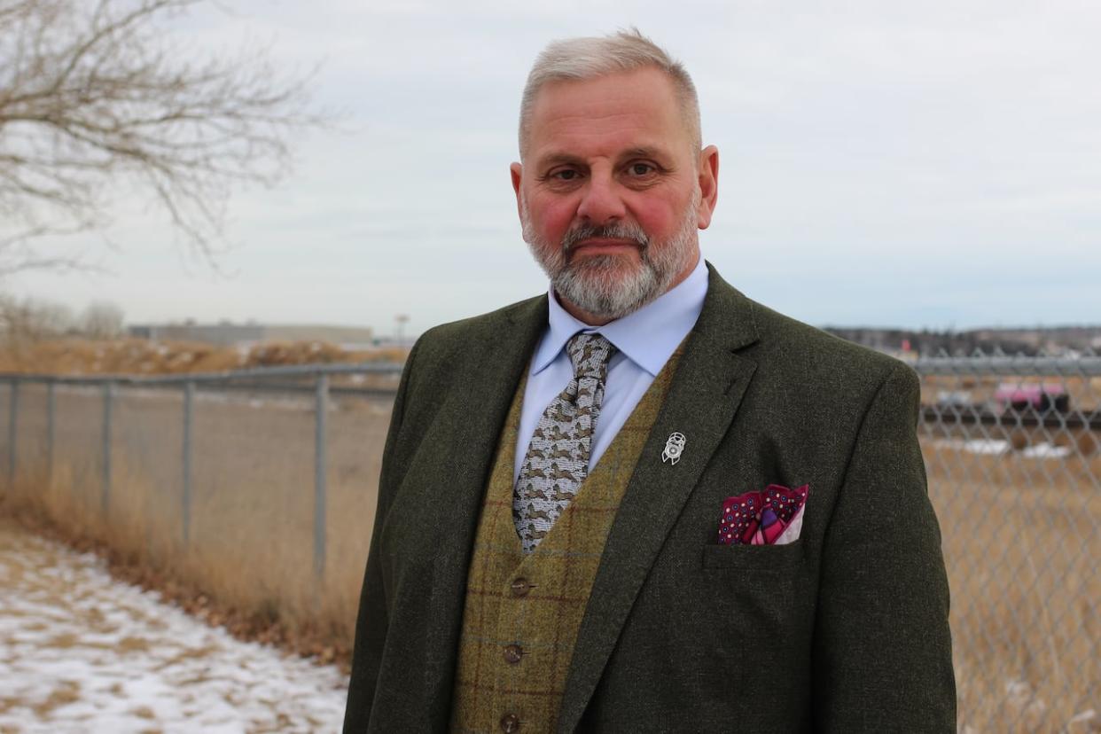 Mark Bretherton is pictured near the railway tracks in Cochrane, Alta.  (Paula Duhatschek/CBC - image credit)