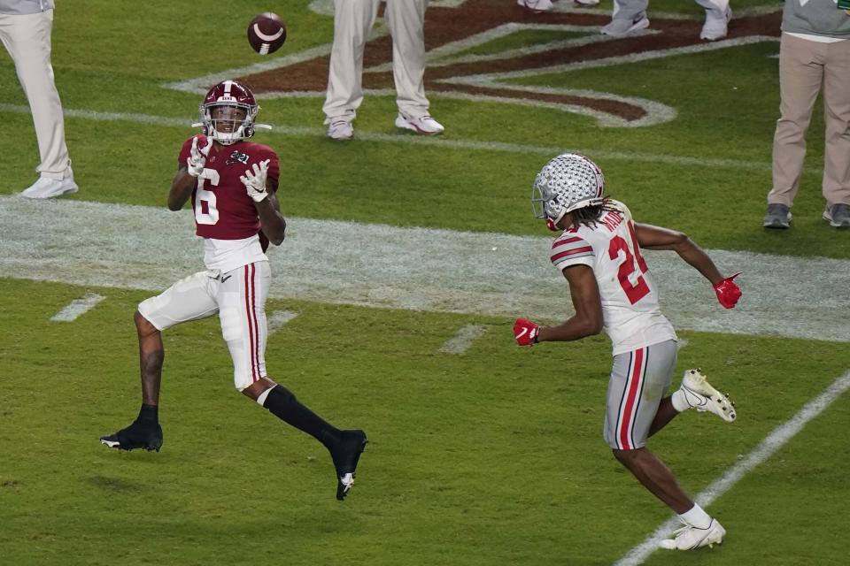 Alabama wide receiver DeVonta Smith catches a touchdown pass in front of Ohio State cornerback Shaun Wade during the first half of an NCAA College Football Playoff national championship game, Monday, Jan. 11, 2021, in Miami Gardens, Fla. (AP Photo/Wilfredo Lee)