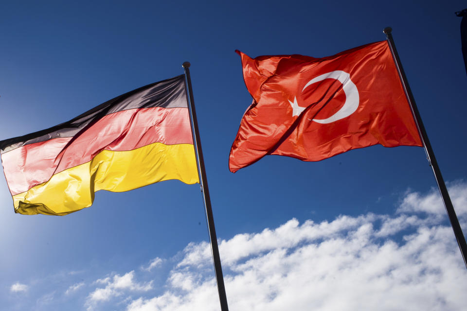 A German and Turkish flag wave at the airport Tegel prior to the arrival of Turkey's President Recep Tayyip Erdogan for an official state visit in Germany at the capital Berlin, Thursday, Sept. 27, 2018. (AP Photo/Markus Schreiber)