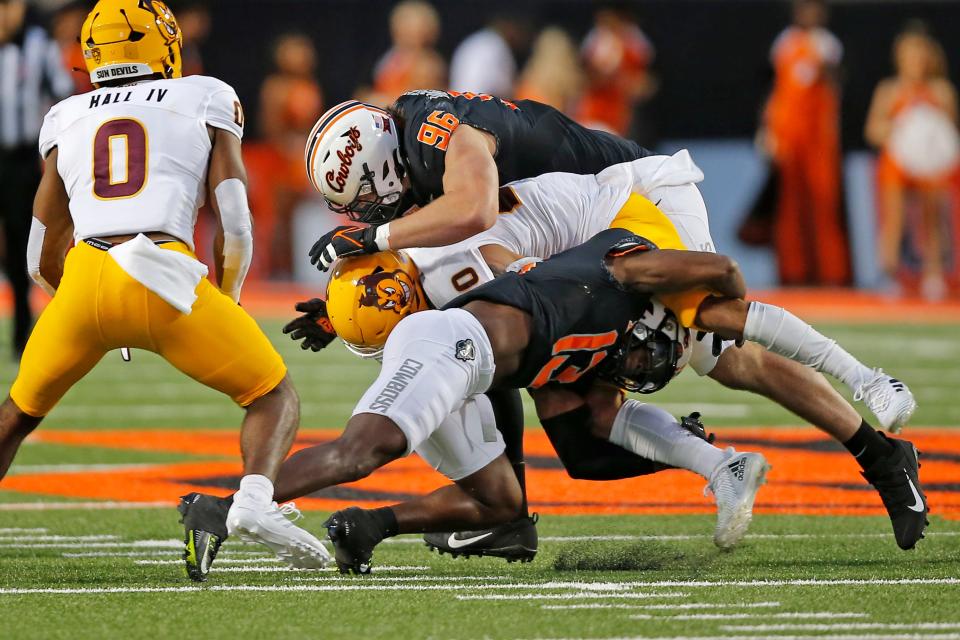 Oklahoma State's Thomas Harper (13) and Kody Walterscheid (96) bring down Arizona State's Giovanni Sanders (20) during a college football game between the Oklahoma State Cowboys (OSU) and the Arizona State Sun Devils at Boone Pickens Stadium in Stillwater, Okla., Saturday, Sept. 10, 2022. Oklahoma State won 34-17