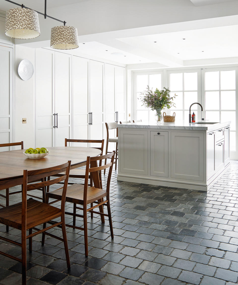 <p> A common brickwork pattern, the running bond style, as seen in this kitchen above, can create a clean floor tile design that embodies a subtle, industrial feel. </p> <p> The dark stone used for the tiles in this kitchen perfectly complement the all white scheme, creating a stylish element of contrast that makes the overall design feel grounded. </p> <p> Whether laid vertically or horizontally, this traditional tile design can integrate into homes of all styles, creating a smart and orderly effect. </p>