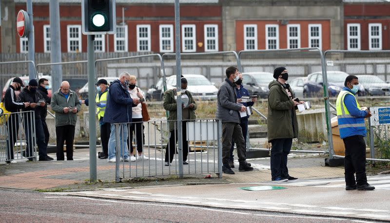 People queue to undertake a coronavirus disease (COVID-19) test at a walk-in test facility in Bolton, Britain