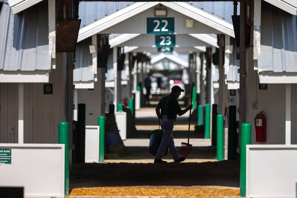 A worker walks through the barn area on the opening day of the Keeneland Fall Meet on Friday.