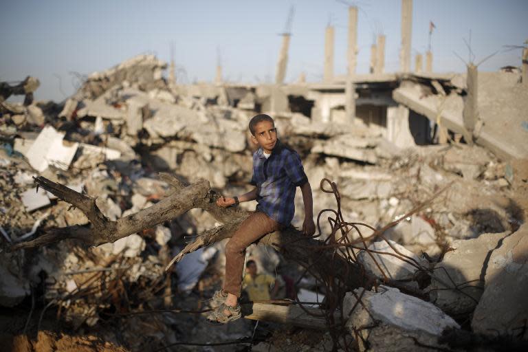 A Palestinian sits amid the rubble of buildings that were destroyed during the 50-day war between Israel and Hamas militants in the summer of 2014, in Gaza City's al-Shejaiya neighbourhood, on March 31, 2015