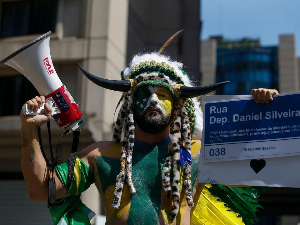 A man takes part in a demonstration in support of Brazilian President Jair Bolsonaro in Sao Paulo, Brazil wearing a headress and face paint