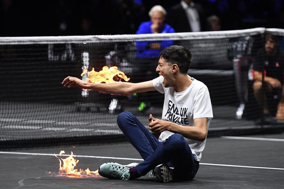 A climate change activist protests against UK private jets while lighting his right arm on fire during the Laver Cup tennis tournament at the O2 Arena in London, Britain, 23 September 2022.