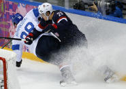 Lauri Korpikoski of Finland (28) and Ryan Suter of the United States (20) crash into the boards during the third period of the men's bronze medal ice hockey game at the 2014 Winter Olympics, Saturday, Feb. 22, 2014, in Sochi, Russia. (AP Photo/Matt Slocum)