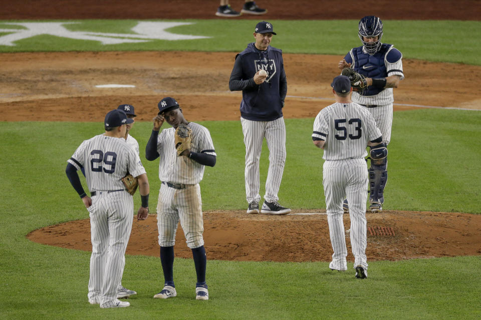 New York Yankees shortstop Didi Gregorius, third from left, talks with third baseman Gio Urshela (29) and second baseman Gleyber Torres as relief pitcher Zack Britton (53) enters the game replacing pitcher Adam Ottavino (0) during the eighth inning of Game 3 of baseball's American League Championship Series against the Houston Astros, Tuesday, Oct. 15, 2019, in New York. (AP Photo/Seth Wenig)