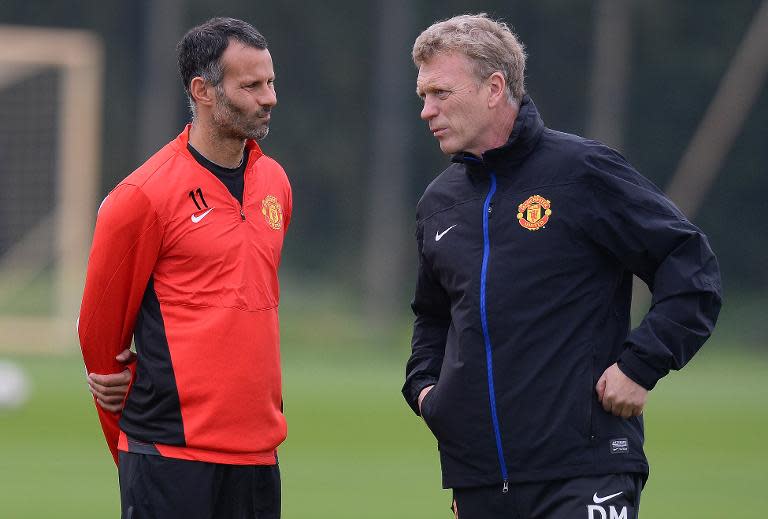 Then-Manchester United manager David Moyes (R) speaks to Ryan Giggs during a training session at the team's Carrington training complex in Manchester, north-west England on October 1, 2013
