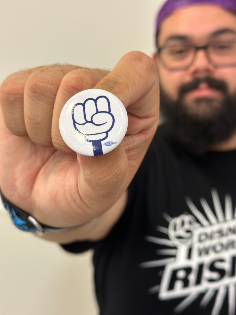 Disneyland employee Daniel Rodriguez holds a Magic United union pin on June 12, 2024.