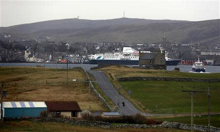 Boys walk up the centre of the road on the small island of Bressay situated of the east coast of mainland Shetland after taking the ferry across from Lerwick (in the distance) on the Shetland Islands April 4, 2014. REUTERS/Cathal McNaughton