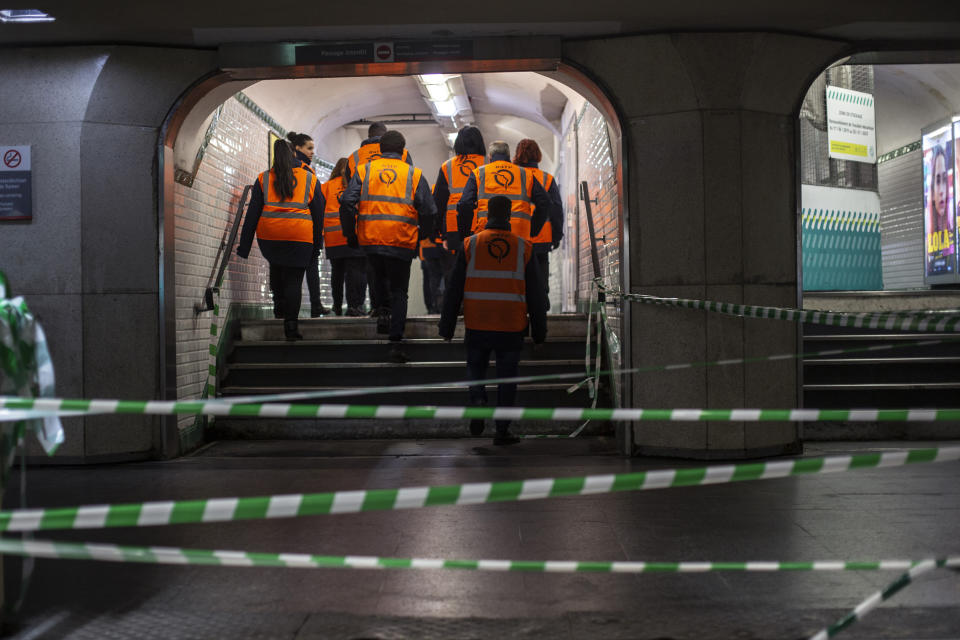 Paris subway employees walk in a corridor of a subway station in Paris, Monday, Dec.9, 2019. Paris commuters inched to work Monday through exceptional traffic jams, as strikes to preserve retirement rights halted trains and subways for a fifth straight day. Citing safety risks, the SNCF national rail network issued warned travelers to stay home or use "alternate means of locomotion" to get to work Monday instead of thronging platforms in hopes of getting the few available trains. (AP Photo/Rafael Yaghobzadeh)