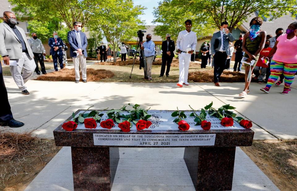 The April 27, 2011 tornado anniversary was marked in Rosedale Court with the dedication of a park bench in memory of the nine people  killed in the housing authority property Tuesday, April 27, 2021. Nine roses are laid across the bench in memory of the nine who lost their lives. [Staff Photo/Gary Cosby Jr.]