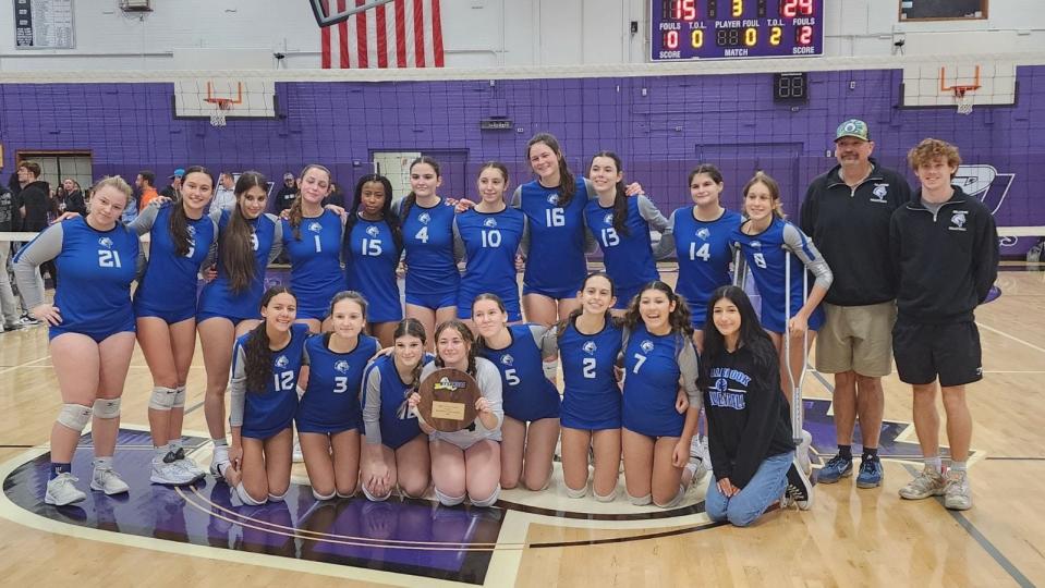 The Millbrook volleyball team poses on the court at Port Jefferson High School after winning the Class C regional final on Nov. 11, 2023.