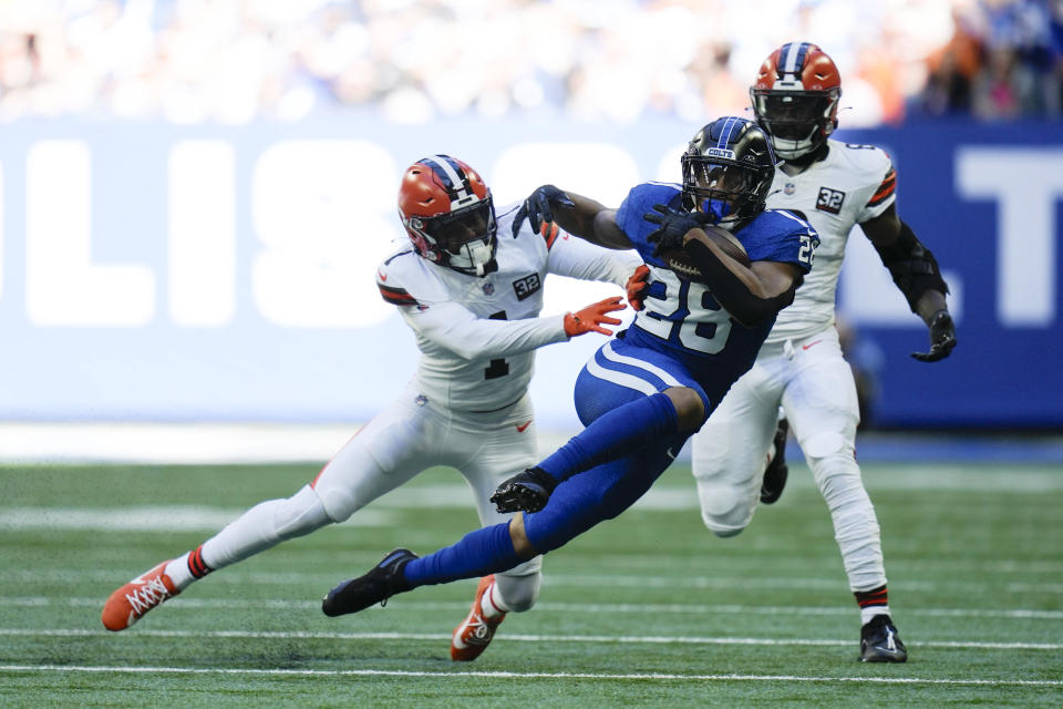 Indianapolis Colts running back Jonathan Taylor (28) runs from Cleveland Browns safety Juan Thornhill (1) during the first half of an NFL football game, Sunday, Oct. 22, 2023, in Indianapolis. (AP Photo/Michael Conroy)