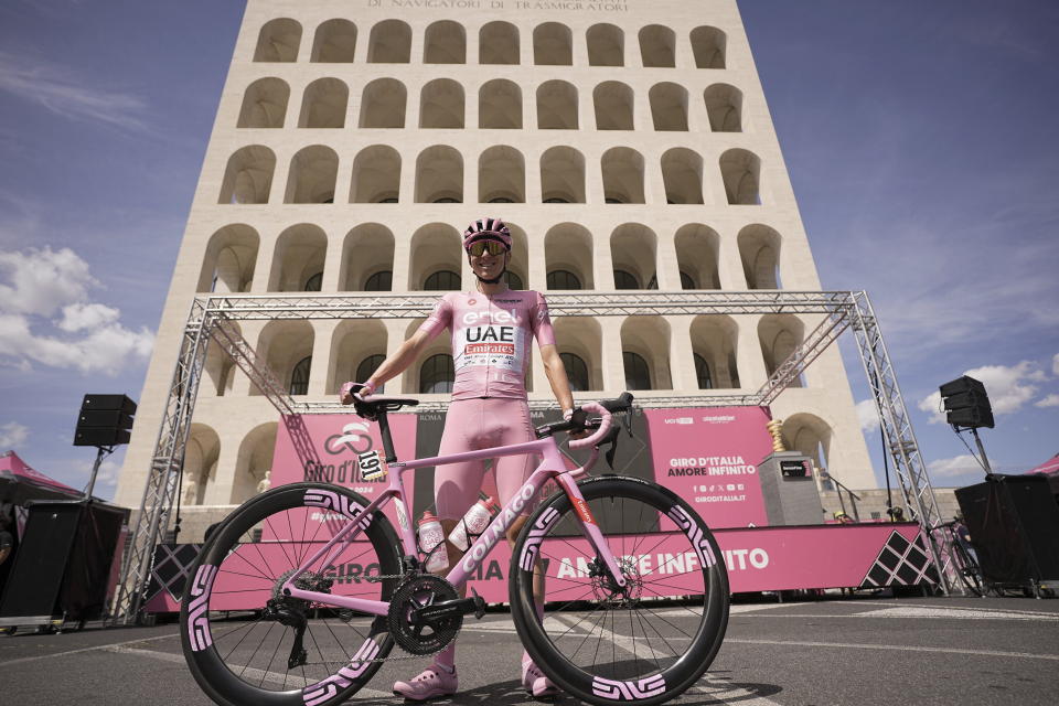 Slovenia's Tadej Pogacar, 2nd right, wearing the pink jersey of the race overall leader, poses as he waits for the start of the final stage of the Giro d'Italia cycling race, in front of the Palazzo della Civilta' Italiana, also known as Colosseo Quadrato (Square Colosseum) in Rome, Sunday, May 26, 2024. (Marco Alpozzi/LaPresse via AP)