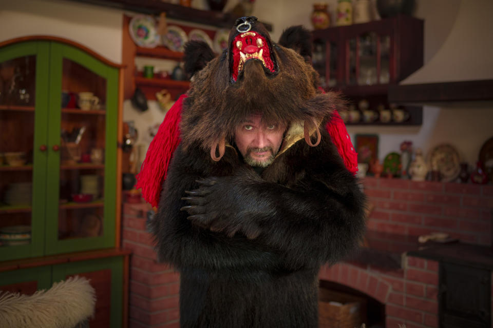 Costel, 46 years-old, the founder of the Sipoteni bear pack, poses for a portrait in Comanesti, northern Romania, Wednesday, Dec. 27, 2023. Costel, who first wore the bear fur costume when he was 8 years-old, says "the bear runs through our veins, it is the spirit animal for those in this area". (AP Photo/Andreea Alexandru)
