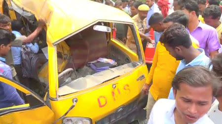 People gather around a school bus after it collided with a train in Uttar Pradesh, India April 26, 2018, in this screen grab taken from video. ANI via REUTERS