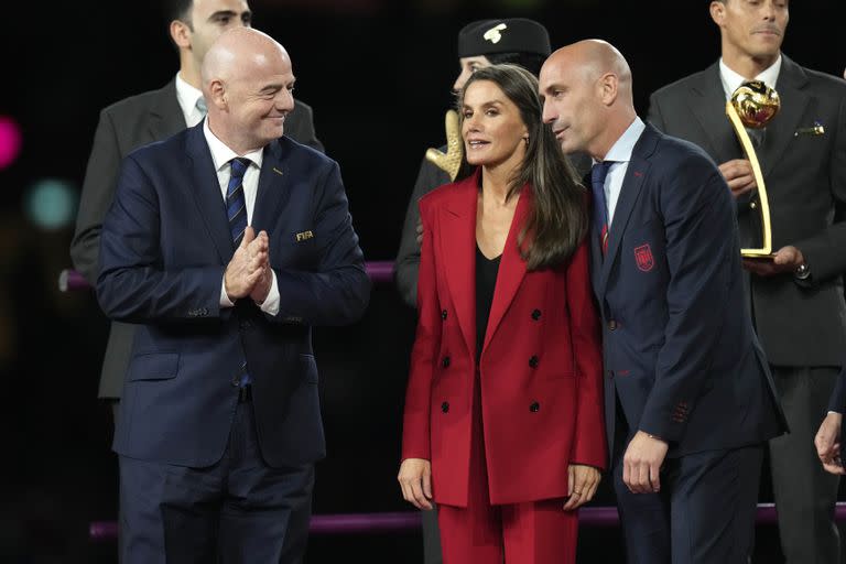 Desde la izquierda, el presidente de la FIFA Gianni Infantino, la Reina Letizia y el presidente de la federación española de fútbol, Luis Rubiales, durante la ceremonia de premiación del Mundial femenino, ganado por España, el domingo 20 de agosto de 2023, en Sydney. (AP Foto/Alessandra Tarantino)