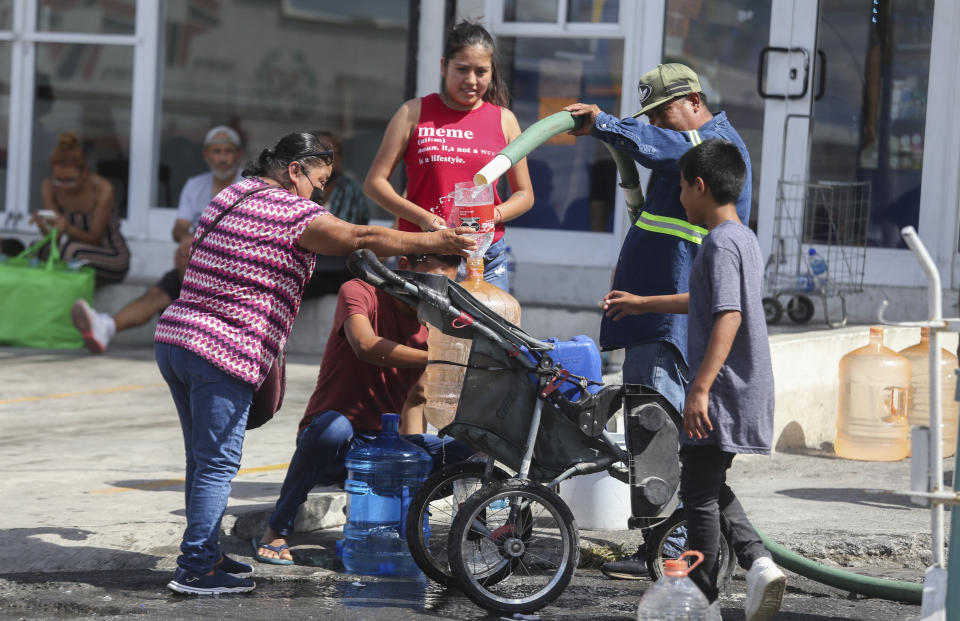 Vecinos llenan garrafas de plástico con agua en un punto de suministro público en Monterrey, México, el 20 de junio de 2022. Las autoridades locales comenzaron a restringir el suministro de agua en marzo debido a la combinación de una intensa sequía, una mala planificación y un uso excesivo que ha secado las tres presas que abastecen a la ciudad, y miles de viviendas no reciben agua desde hace semanas. (AP Foto)