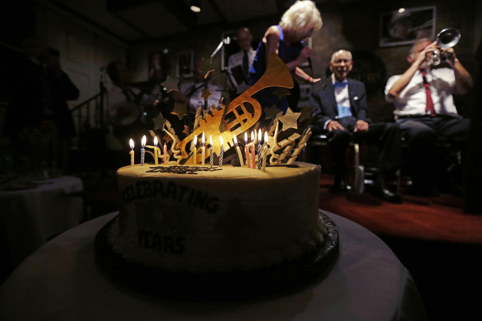 Dixieland jazz musician Lionel Ferbos is honored with a cake at his 102nd birthday party at the Palm Court Jazz Cafe in New Orleans, Wednesday, July 17, 2013. Ferbos, who bought his first cornet at a Rampart Street pawn shop when he was 15, is believed to be the oldest actively working musician in the city. His body isn’t without signs of age. He’s been in and out of the hospital in recent years and had a pacemaker implanted last year. He sometimes uses a wheelchair to get around, but he remains determined to sing and blow. (AP Photo/Gerald Herbert)