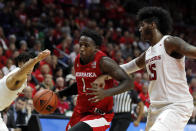 Nebraska forward Kevin Cross, center, drives to the basket between Rutgers guard Geo Baker, left, and center Myles Johnson, right, during the first half of an NCAA college basketball game Saturday, Jan. 25, 2020, in Piscataway, N.J. Rutgers won 75-72. (AP Photo/Adam Hunger)