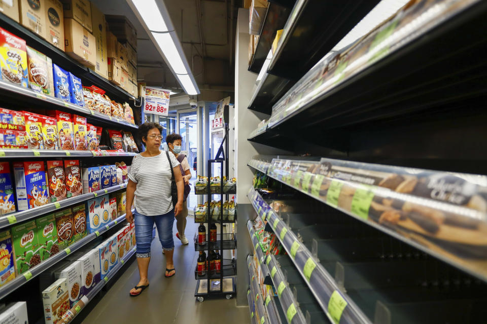 Shoppers walk past empty shelves for bread at a supermarket as super typhoon Saola approaches Hong Kong on Friday, Sept. 1, 2023. Most of Hong Kong and parts of southern China ground to a near standstill as Super Typhoon Saola edged closer Friday. (AP Photo/Daniel Ceng)
