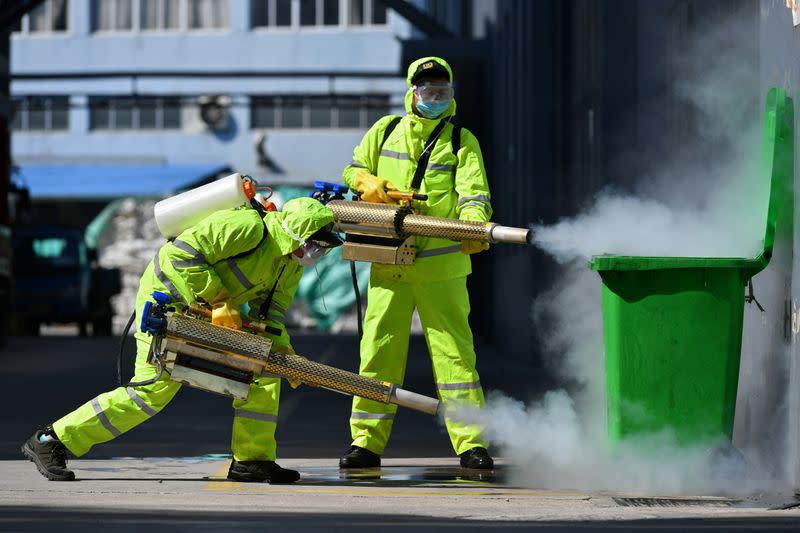 Volunteers in protective suits disinfect a factory with sanitizing equipment, as the country is hit by an outbreak of the novel coronavirus, in Huzhou