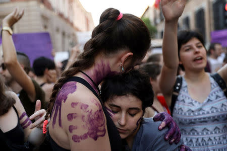 Protesters embrace during a demonstration against the release on bail of five men known as the "Wolf Pack" cleared of gang rape of a teenager and convicted of a lesser crime of sexual abuse in Madrid, Spain, June 22, 2018. REUTERS/Susana Vera