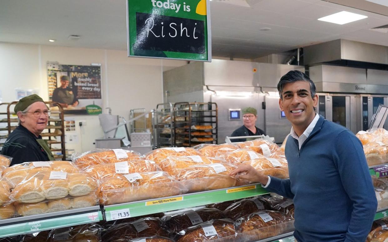 Rishi Sunak puts bread on the shelves at a Morrisons supermarket in Carterton, Oxfordshire