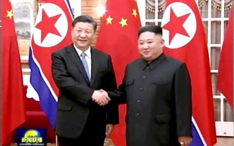 In this image taken from a video footage run by China's CCTV, Chinese President Xi Jinping, left, and North Korean leader Kim Jong Un, right, shake hands before their meeting in Pyongyang - Credit: CCTV via AP