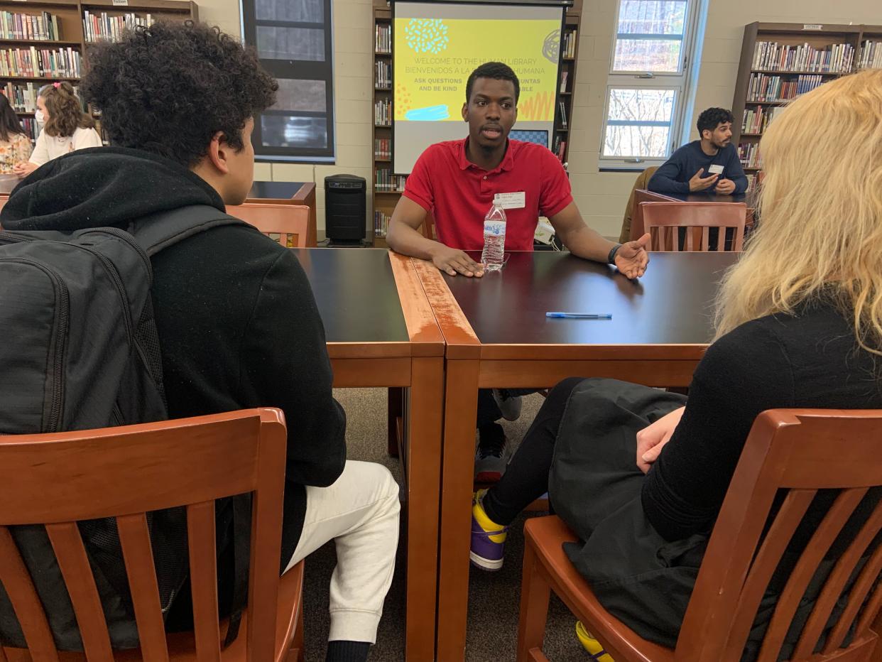 Maurice Newman chats with students about his experiences being a gay refugee from Jamaica during the school's "human library" event on at a high school in Massachusetts.