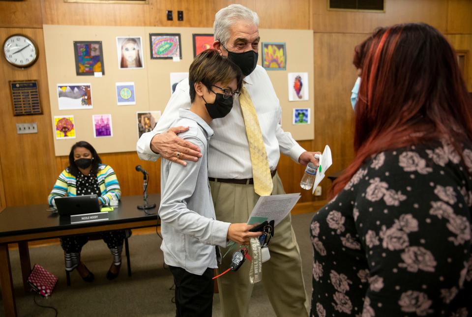 Southeast senior Vinny Le gets a hug from District 186 Board of Education Vice President Mike Zimmers, while being congratulated as well by District 5 Board Member Buffy Lael-Wolf, right, after giving public comments in support of the district’s efforts for masking and vaccines to keep kids in school during a school board meeting at the District 186 Headquarters in Springfield, Ill., Monday, October 4, 2021. [Justin L. Fowler/The State Journal-Register] 