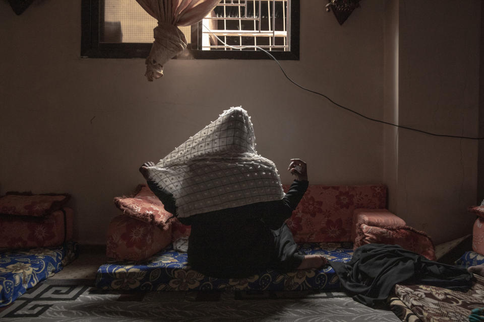 In this July 20, 2019 photo, 20-year-old Ethiopian migrant Zahra, a rape victim, adjusts her veil for a photograph, in Basateen, a district of Aden, Yemen. She was imprisoned for a month in a tin-roofed hut, broiling and hungry, ordered to call home each day to beseech her family to wire $2,000. She said she did not have family to ask for money and pleaded for her freedom. Instead, her captors raped her. (AP Photo/Nariman El-Mofty)