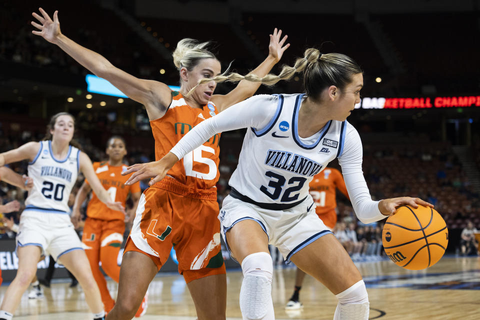 Villanova's Bella Runyan (32) dribbles around Miami's Hanna Cavinder (15) in the first half of a Sweet 16 college basketball game of the NCAA Tournament in Greenville, S.C., Friday, March 24, 2023. (AP Photo/Mic Smith)