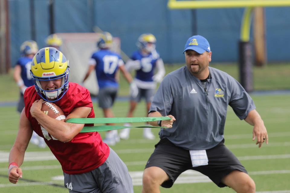 Delaware offensive coordinator Jared Ambrose works with quarterback Nolan Henderson in preseason camp on Wednesday, July 31, 2019.