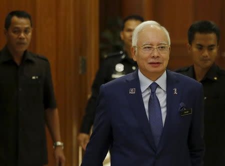 Malaysia's Prime Minister Najib Razak arrives with his security detail at a news conference to announce measures to strengthen the economy in Putrajaya, Malaysia, September 14, 2015. REUTERS/Olivia Harris