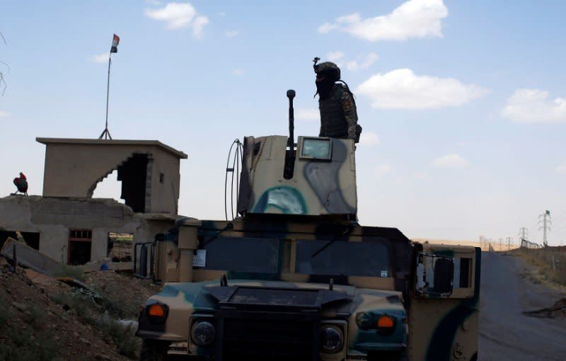 A member of Iraqi security forces stands on the turret of an armoured vehicle along a highway near west of Mosul, Iraq June 22, 2017. REUTERS/Erik De Castro