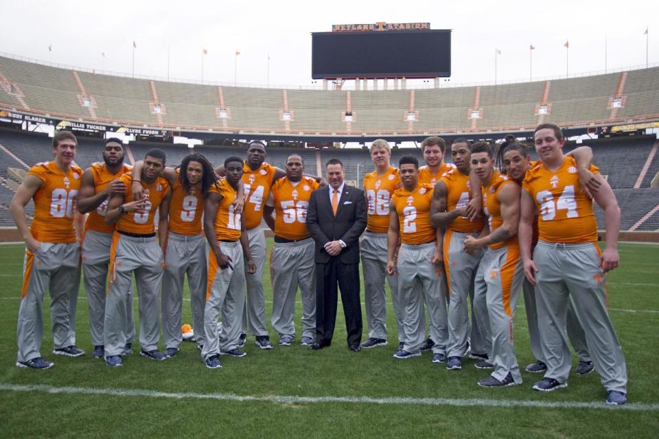 University of Tennessee NCAA college football coach Butch Jones, center, poses with his signing class' midterm enrollees on Wednesday, Feb. 5, 2014, in Knoxville, Tenn. The players are, from left to right: Daniel Helm, Neiko Creamer, Josh Malone, Von Pearson, Emmanuel Moseley, Dontavius Blair, Owen Williams, Ethan Wolf, D'Andre Payne, Coleman Thomas, Dimarya Mixon, Jalen Hurd, Jakob Johnson, and Ray Raulerson. (AP Photo/Knoxville News Sentinel, Saul Young)