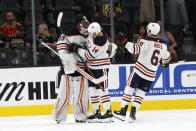 Edmonton Oilers goaltender Mikko Koskinen (19), center Devin Shore (14) and defenseman Kris Russell (6) celebrate the team's 5-3 victory over the Vegas Golden Knights in an NHL hockey game Friday, Oct. 22, 2021, in Las Vegas. (AP Photo/Steve Marcus)