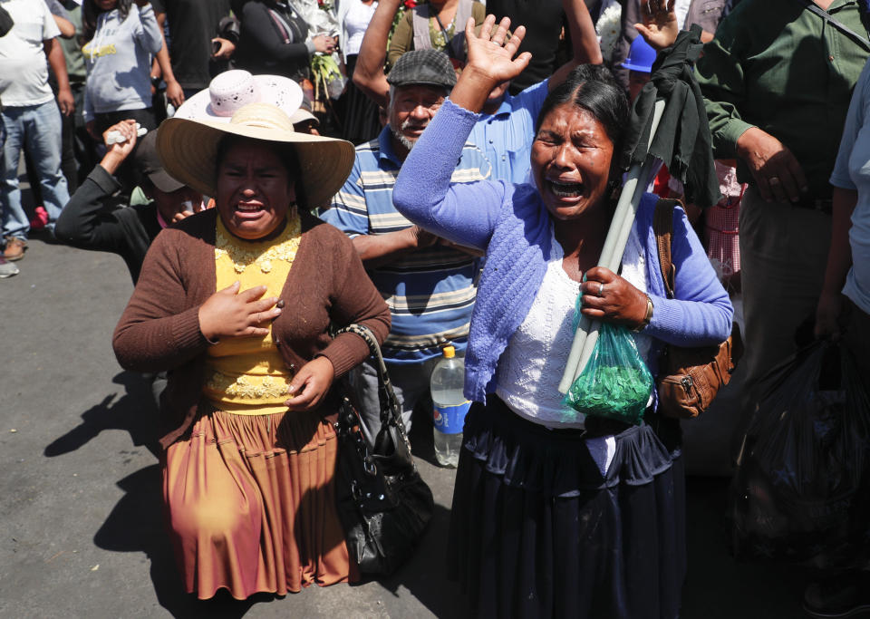 Coca growers kneel during a protest of backers of former President Evo Morales in Sacaba, Bolivia, Saturday, Nov. 16, 2019. Bolivia's political crisis turned deadly after security forces opened fire on Morales' supporters in Sacaba Friday, killing at least five people, injuring dozens and threatening the interim government's efforts to restore stability following the resignation of the former president in an election dispute. (AP Photo/Juan Karita)