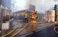 <p>Los Angeles firefighters battle to contain flames to a home on fire and prevent the fire’s spread to adjoining properties in the Bel Air district of Los Angeles Wednesday, Dec. 6, 2017. (Photo: Reed Saxon/AP) </p>